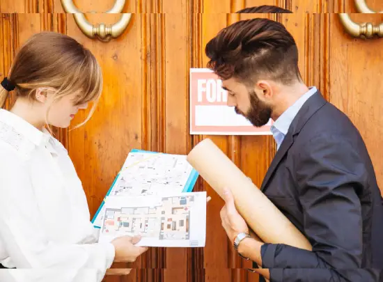 Architects or project managers reviewing floor plans outside a property for renovation in Dubai.
